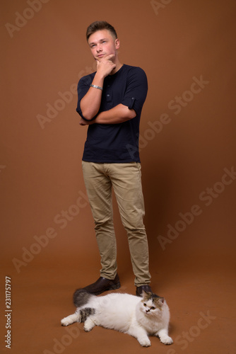 Foto Studio shot of young handsome man against brown background