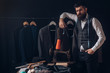 Perfect design. business dress code. Handmade. retro and modern tailoring workshop. suit store and fashion showroom. sewing mechanization. Bearded man tailor sewing jacket. Another client