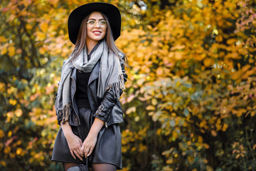 beautiful woman in black dress and hat in autumn