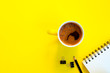Notebook, pencil and coffee cup on yellow background.