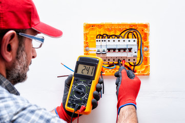 Wall Mural - Electrician at work on an electrical panel.