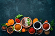 A set of spices and herbs on a stone table. Indian traditional spices. Top view. Free copy space.