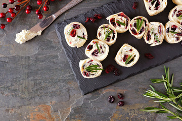 Poster - Cranberry, cream cheese pinwheel appetizers. Holiday food concept. Top view, on a dark background.