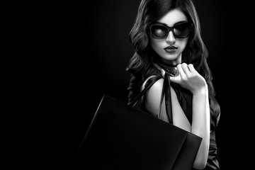 Shopping woman holding grey bag isolated on dark background in black friday holiday