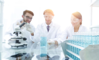 Wall Mural - background image of scientists studying blue liquid in a flask