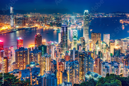 Obraz Dibond Sceniczny widok nad Hong Kong wyspą, Chiny, nocą. Wielokolorowa nocna linia horyzontu z oświetlonymi wieżowcami widzianymi z Victoria Peak