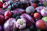 Fototapeta Sawanna - Background of fresh vegetables and fruits. Purple eggplant, backberries, grapes, plums, figs, apples, grape and garlic. Top view. Purple food.