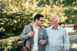 © bnenin - Two friendly men walking in the park.