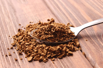  instant coffee in a spoon on a wooden background. Flavored coffee