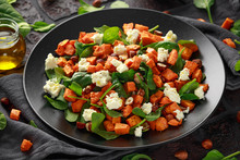 Healthy Roasted Sweet Potato Salad With Spinach, Feta Cheese, Hazelnut Nuts In Black Plate, Rustic Background