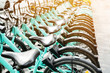 © tatomm - Bicycle rental service on city road parking with sunlight, public transportation concept.