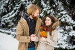 © Elizaveta - Young Caucasian boy and girl in love heterosexual couple have a date outdoors in a winter park on the background of a snowy conifer standing in an embrace. Man hugging woman valentines day