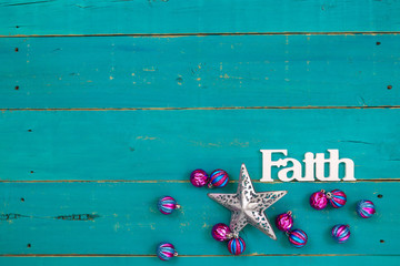 Wall Mural - The word Faith hanging on antique rustic teal blue wooden background with colorful turquoise and pink Christmas ornaments and silver star;  religious holiday and spiritual wood sign with copy space