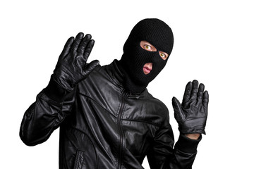 Arrested masked thief with raised arms isolated on white background