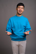 © Ranta Images - Portrait of young Asian man against gray background