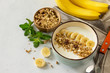© elena_hramowa - Granola. Granola with yogurt, chocolate and banana on a white stone table.