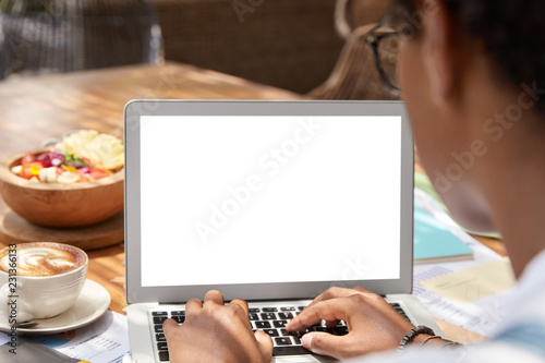Fotografía Females hands types text on modern laptop keyboard, develops personal website, makes research, works on notebook with blank copy screen for advertising information content