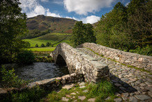 Old Cobbled Stone Bridge Over River Derwent In The Borrowdale Valley, Lake District, England, UK