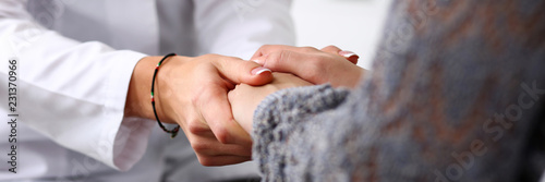 Cuadros en Lienzo Friendly female doctor hold patient hand in office during recept