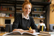 © Drobot Dean - Smiling red haired teenage girl studying