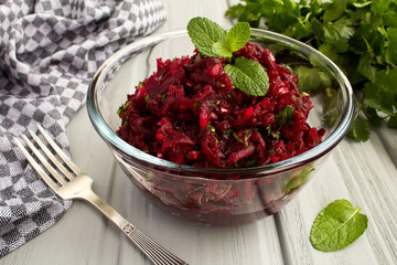 Wall Mural - Salad with grated beets and herbs in the glass bowl on the grey wooden  background