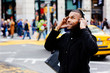 © Carlos David - Portrait of a young man standing on the street and enjoying listening with his headphones, New York City