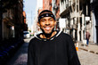 © Carlos David - Portrait of a cool young man with a bandana smiling at camera on the street of New York City