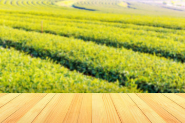 Wall Mural - empty wooden table on tea plantations background, with copy space