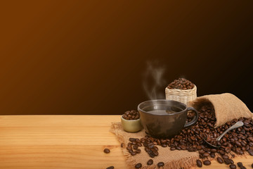 Hot cup of coffee and beans with burlap sack on the wooden table, with copy space