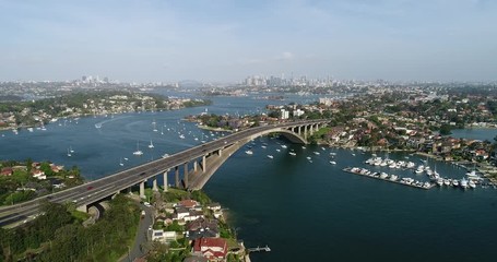 Sticker - Descending in view of Gladesville bridge across Parramatta river in Sydney inner West. Distant Sydney city CBD towers on the horizon.
