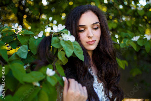 A Young Teenager Girl With Long Dark Hair In A White Dress Standing Under A Blooming Apple Tree Stock Photo Adobe Stock