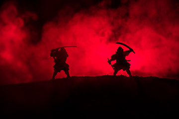 Silhouette of two samurais in duel. Picture with two samurais and sunset sky