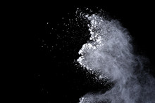 White Powder Explosion On Black Background. Dust Splatted Isolated. Paint Holi.