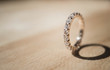 Close up of elegant diamond ring on wooden background. soft and selective focus. Love and wedding concept.