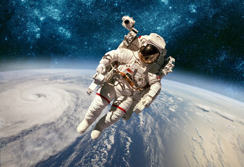 Wall Mural - astronaut in outer space against the backdrop of the planet earth. typhoon over planet earth.