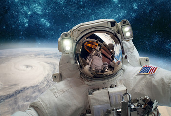 Wall Mural - astronaut in outer space against the backdrop of the planet earth. typhoon over planet earth.