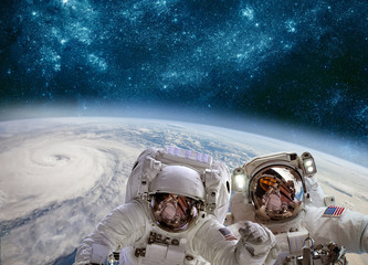 Wall Mural - astronaut in outer space against the backdrop of the planet earth. typhoon over planet earth.
