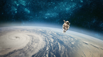 Wall Mural - astronaut in outer space against the backdrop of the planet earth. typhoon over planet earth.