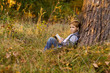 © irina_g - a boy reading a book at sunset under a big tree
