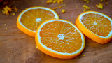 Pokrojone pomarańcze na plasterki leżące na drewnianej desce