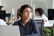 © fizkes - Thoughtful indian business woman looking away feeling bored pensive thinking of problem solution in office with laptop, serious hindu employee searching new ideas at work unmotivated about dull job