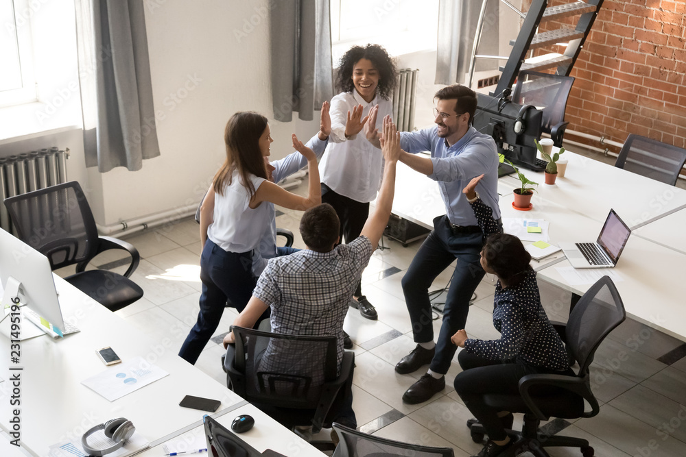 Foto de Stock Excited happy multiracial office team giving high five ...
