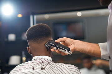 View from back of process of trimming hair in barber shop