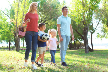 Poster - Family with picnic basket in park on sunny day