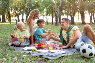 Wall Mural - Happy family having picnic in park on sunny day