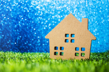 Wall Mural - model house on green grass bokeh blue background
