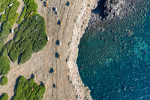 Aerial View Of Some Cows Grazing On The Edge Of A Coast Bathed By A Beautiful And Transparent Sea.