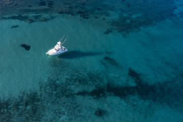 Wall Mural - Aerial view of a little fishing boat on a beautiful and transparent sea. Sardinia, Italy..