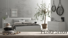 Wooden Vintage Table Shelf With Pebble Balance And 3d Letters Making The Word Feng Shui Over Blurred Bedroom With Window, Chest Of Drawer And Big Olive Tree, Zen Concept Interior Design