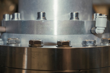 Wall Mural - Detail of vacuum equipment with steel flanges bolted to the vessel in laboratory or industrial environment. Abstract industrial or technology dark background.